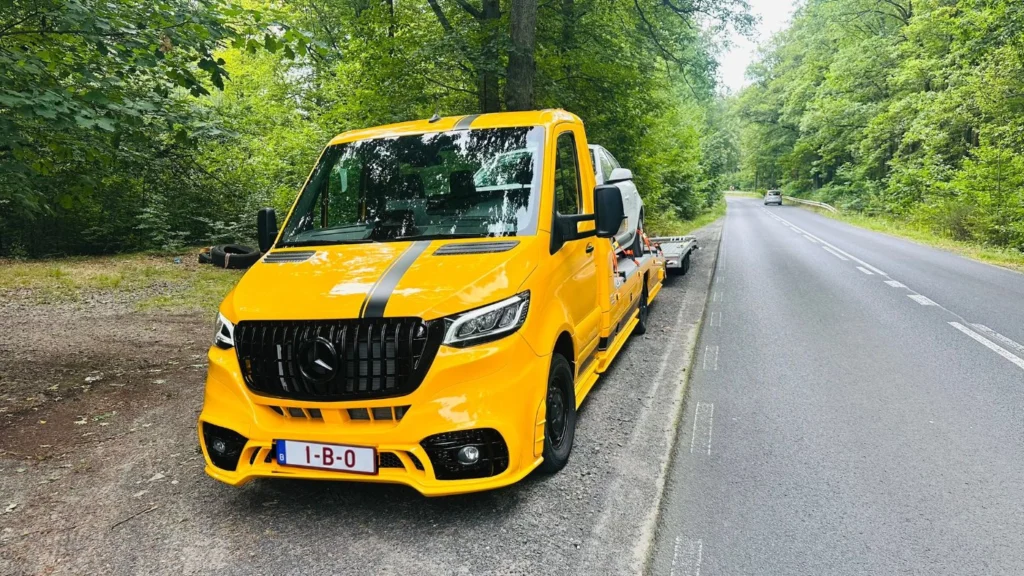 EuroTakel takelwagen met personenwagen langs een bosweg